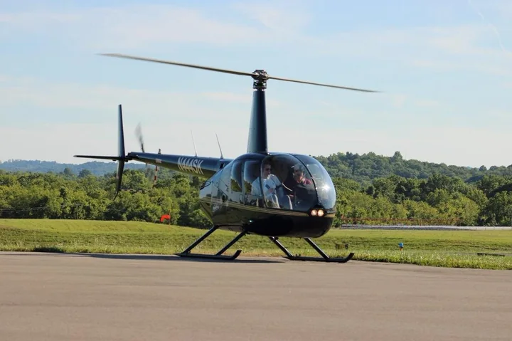 Ein kleiner Vier-Sitzer-Hubschrauber auf einem Flugplatz